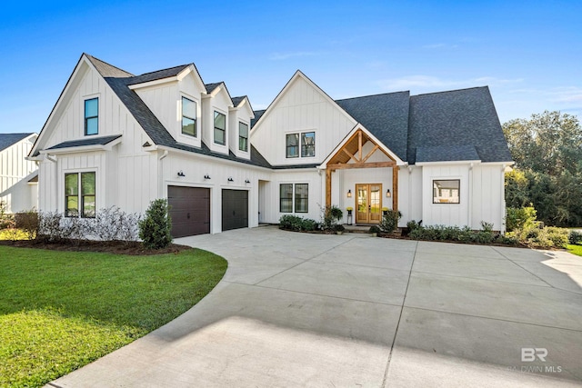 modern inspired farmhouse with a garage, a front yard, and french doors