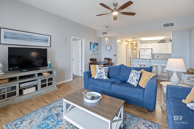 living room with ceiling fan and hardwood / wood-style floors