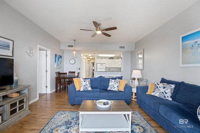 living room featuring ceiling fan and hardwood / wood-style floors