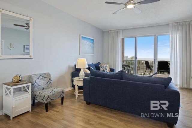 living room with ceiling fan and light hardwood / wood-style flooring