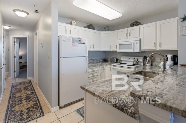 kitchen with white cabinetry, light stone counters, and white appliances