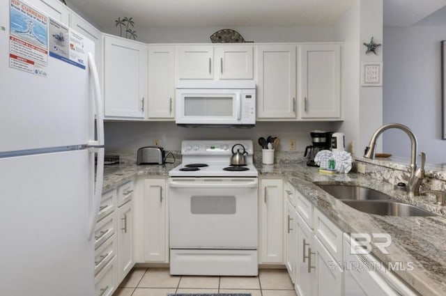 kitchen with white appliances, light tile patterned floors, sink, and white cabinets