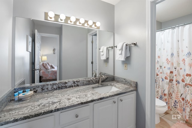 bathroom featuring tile patterned flooring, vanity, and toilet