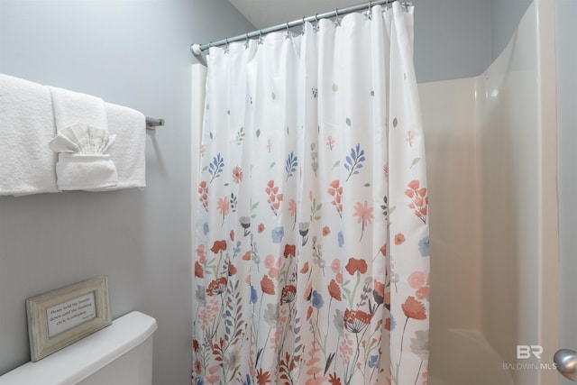 bathroom featuring curtained shower and toilet