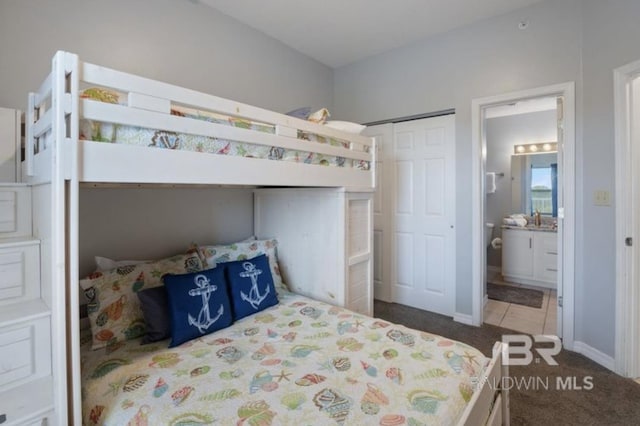 carpeted bedroom featuring ensuite bath and a closet