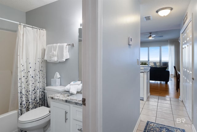 full bathroom featuring shower / tub combo with curtain, tile patterned flooring, vanity, ceiling fan, and toilet