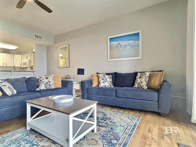 living room featuring ceiling fan and light hardwood / wood-style flooring