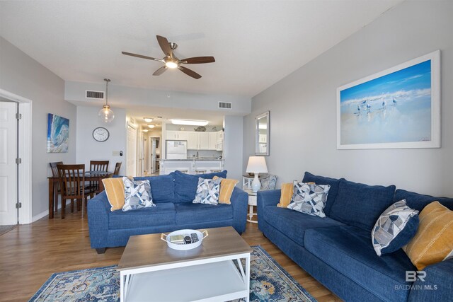 living room with dark hardwood / wood-style floors and ceiling fan