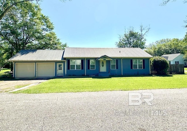 single story home featuring a front lawn, metal roof, aphalt driveway, and an attached garage