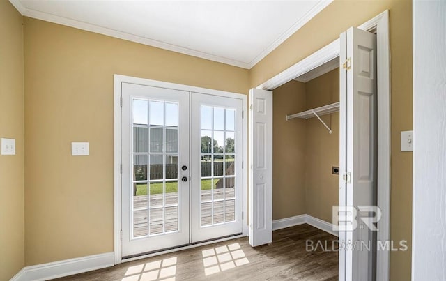 doorway featuring wood finished floors, french doors, crown molding, and baseboards