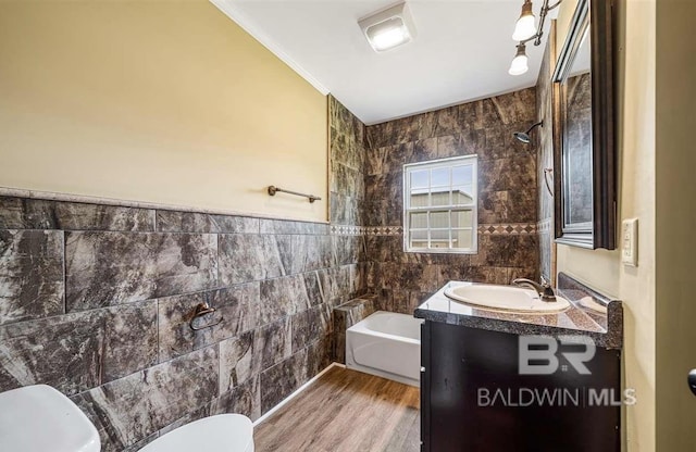 full bath with wood finished floors, tile walls, ornamental molding, toilet, and vanity