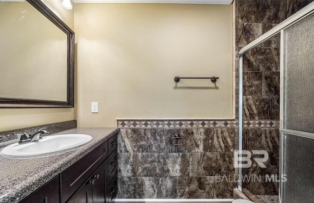 bathroom featuring tile walls, a stall shower, and vanity