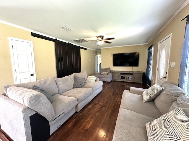 living room featuring crown molding, a barn door, visible vents, dark wood-type flooring, and a ceiling fan