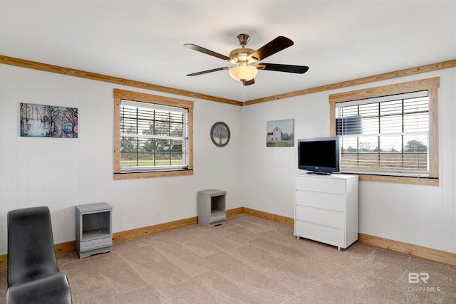 living area with ceiling fan, light colored carpet, and a wealth of natural light