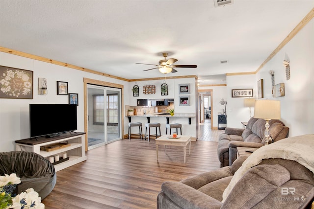 living room featuring hardwood / wood-style flooring, plenty of natural light, and ornamental molding