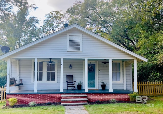 bungalow with a porch and a front lawn