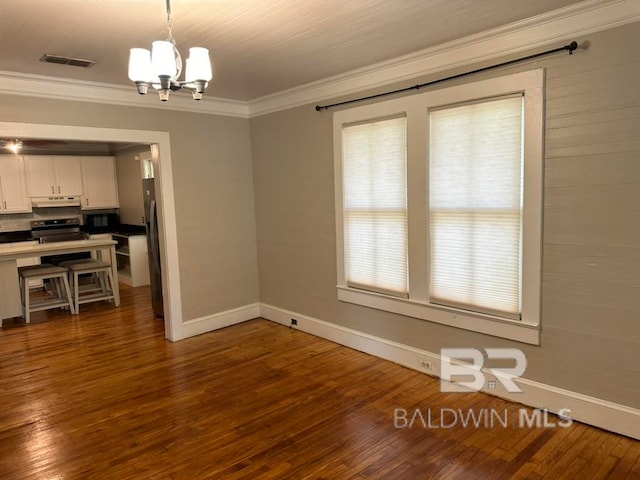 unfurnished dining area with ornamental molding, dark hardwood / wood-style floors, and an inviting chandelier