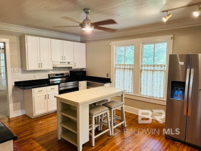 kitchen featuring dark wood-type flooring, white cabinetry, appliances with stainless steel finishes, and ornamental molding