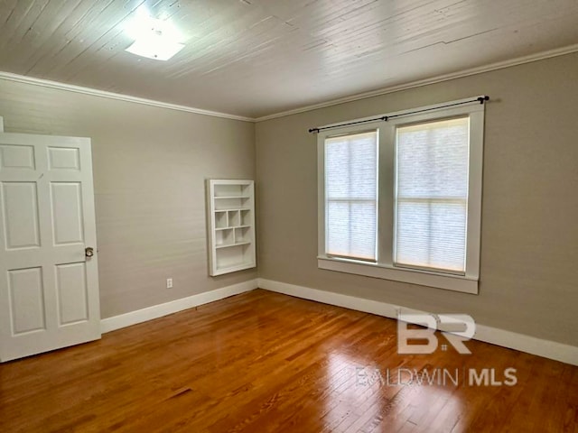 spare room featuring hardwood / wood-style flooring and crown molding