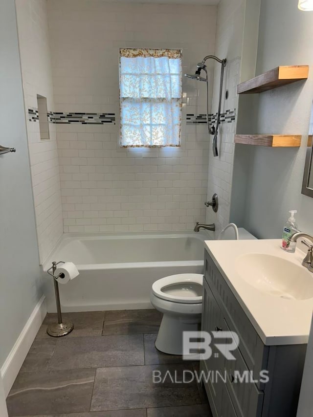 full bathroom with vanity, tiled shower / bath, and toilet