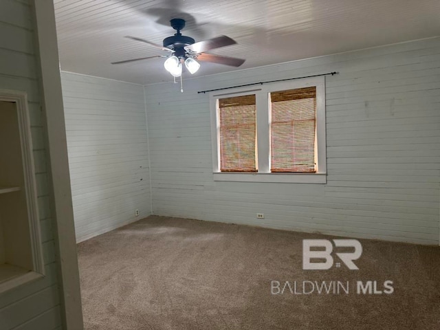 spare room featuring ceiling fan and carpet floors