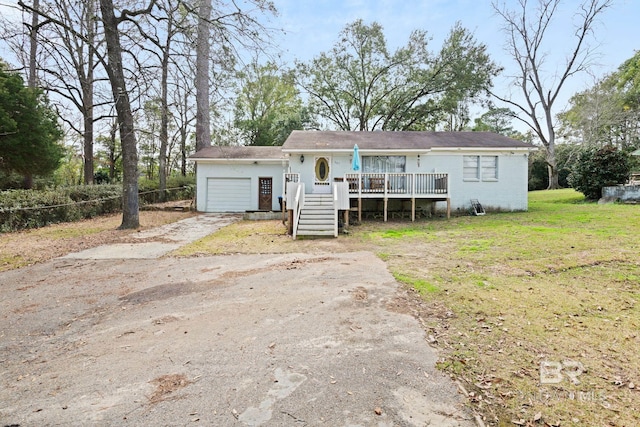 view of front of house featuring a wooden deck, a garage, and a front lawn