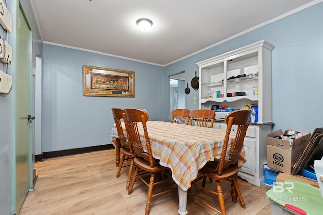 dining room featuring ornamental molding and light hardwood / wood-style floors