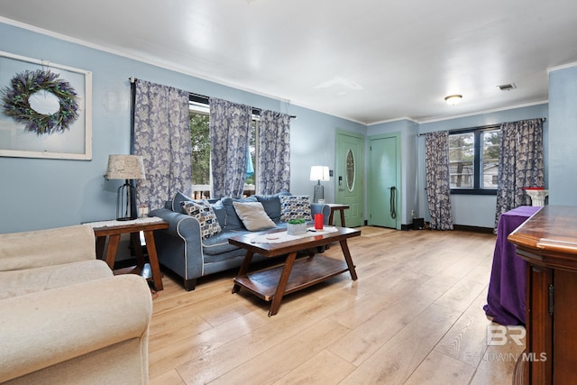 living room with ornamental molding and light hardwood / wood-style flooring