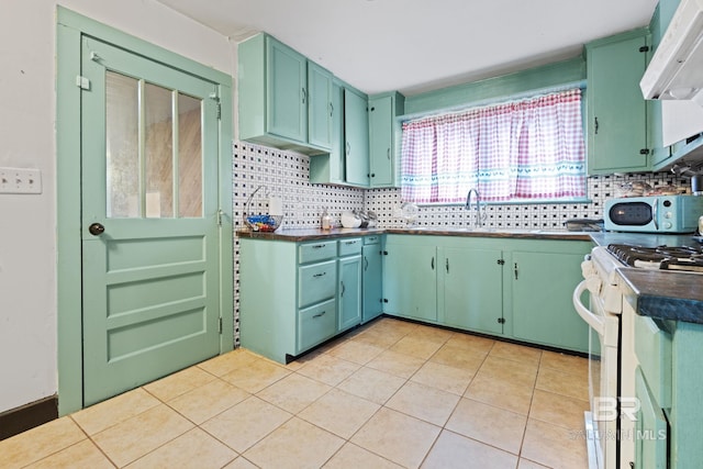 kitchen with extractor fan, white gas stove, backsplash, and green cabinetry