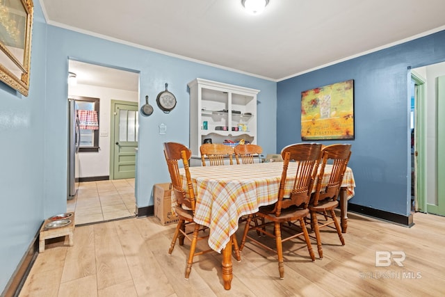 dining area featuring crown molding and light hardwood / wood-style floors