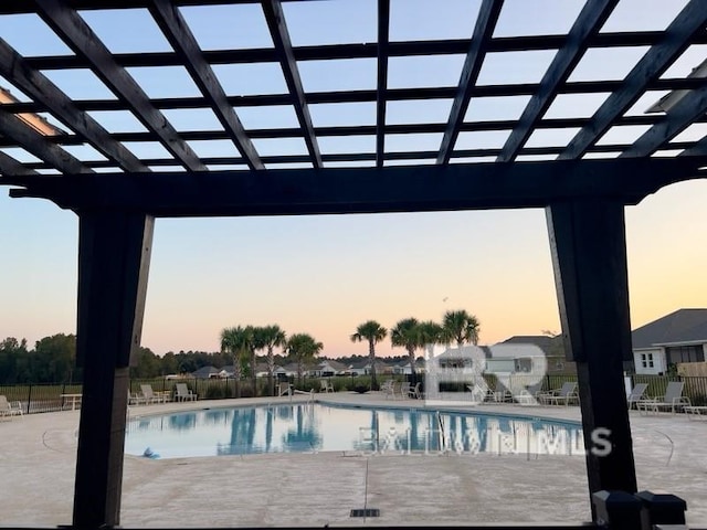 pool at dusk with a patio area, fence, a community pool, and a pergola