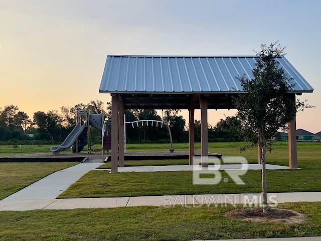 view of home's community featuring playground community and a yard