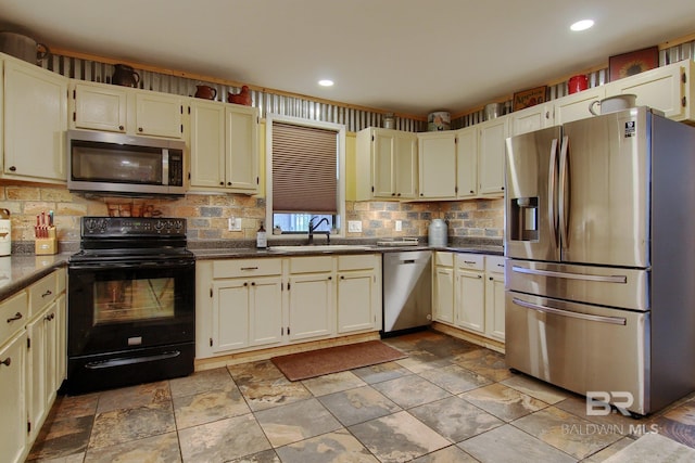 kitchen featuring stainless steel appliances, cream cabinets, sink, and tasteful backsplash