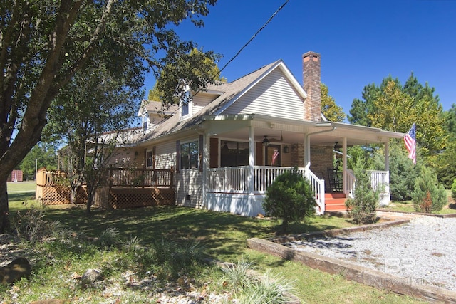 exterior space with covered porch, a lawn, and ceiling fan