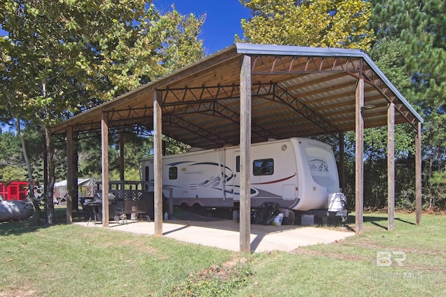 view of parking / parking lot with a yard and a carport