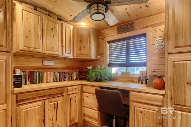 office space with wood ceiling, ceiling fan, built in desk, and wooden walls