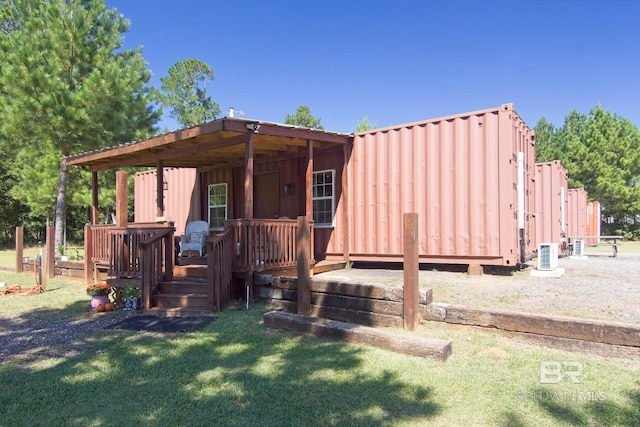 exterior space with a wooden deck, cooling unit, and a yard