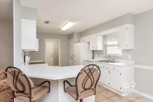 kitchen with white cabinetry, white fridge with ice dispenser, sink, stove, and light tile patterned flooring