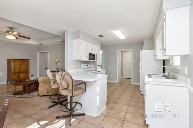 kitchen featuring white cabinetry, sink, ceiling fan, white appliances, and light tile patterned flooring