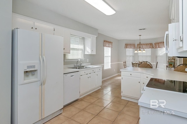 kitchen featuring white cabinetry, sink, hanging light fixtures, a chandelier, and white appliances