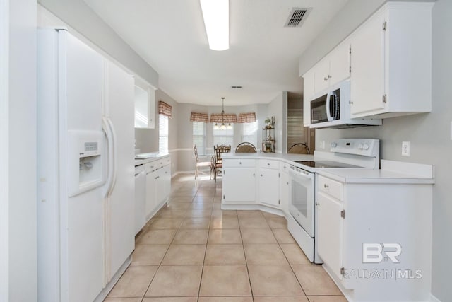 kitchen with kitchen peninsula, white appliances, white cabinets, hanging light fixtures, and light tile patterned flooring