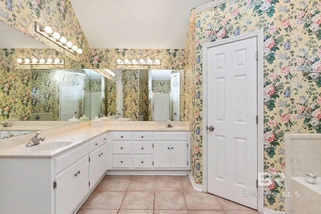 bathroom featuring tile patterned flooring, vanity, and vaulted ceiling