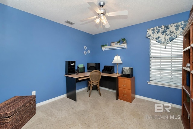 home office featuring ceiling fan, light colored carpet, and a textured ceiling