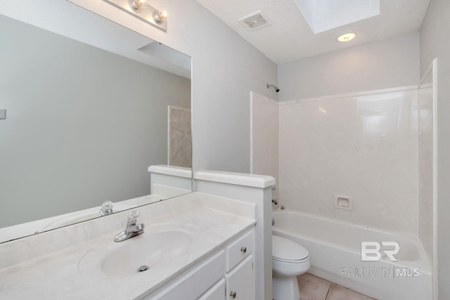 full bathroom with a skylight, tile patterned flooring, toilet, shower / tub combination, and vanity