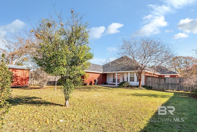 back of house with a lawn and a patio