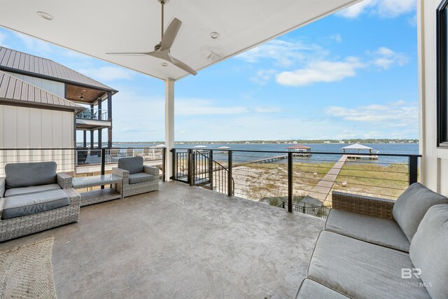 view of patio / terrace with a balcony, a water view, and a ceiling fan