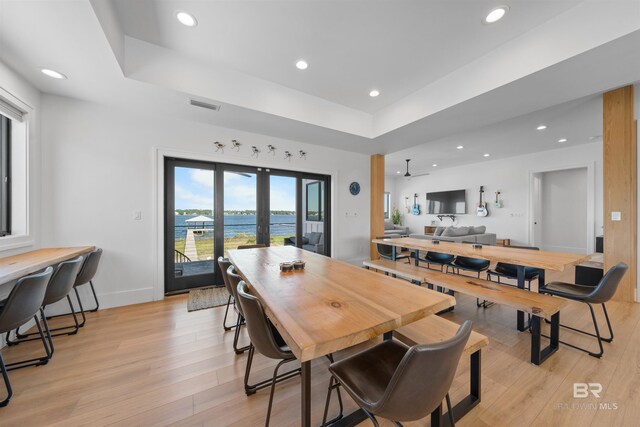dining space with recessed lighting, visible vents, light wood-style floors, and a raised ceiling