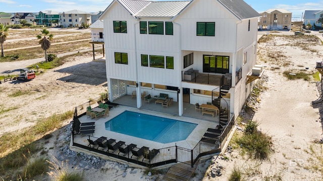 rear view of house featuring stairway, a patio, board and batten siding, a residential view, and a fenced in pool