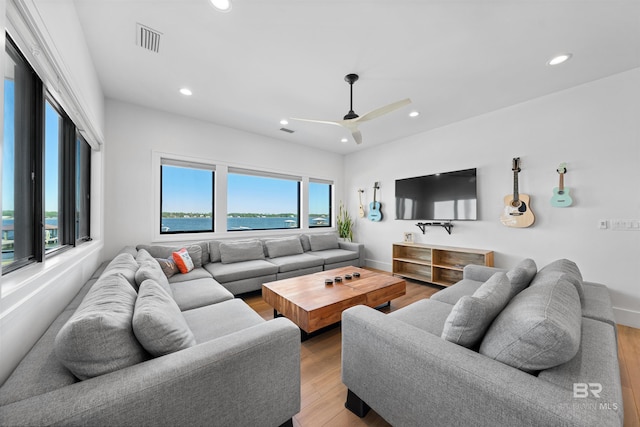 living room featuring visible vents, baseboards, wood finished floors, recessed lighting, and a ceiling fan