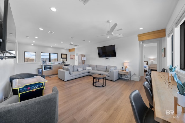 living area with a ceiling fan, visible vents, light wood-style floors, and recessed lighting